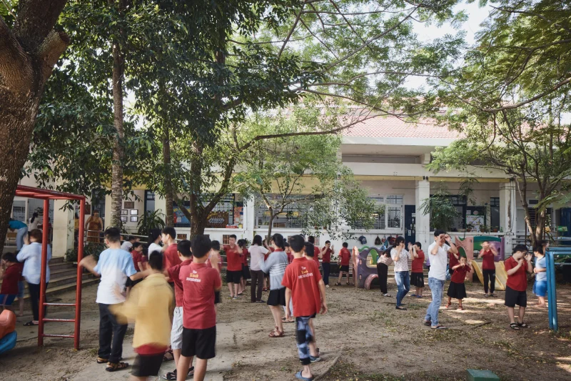 Children and adults using a shaded courtyard at the Dien Ban Disability Day Centre